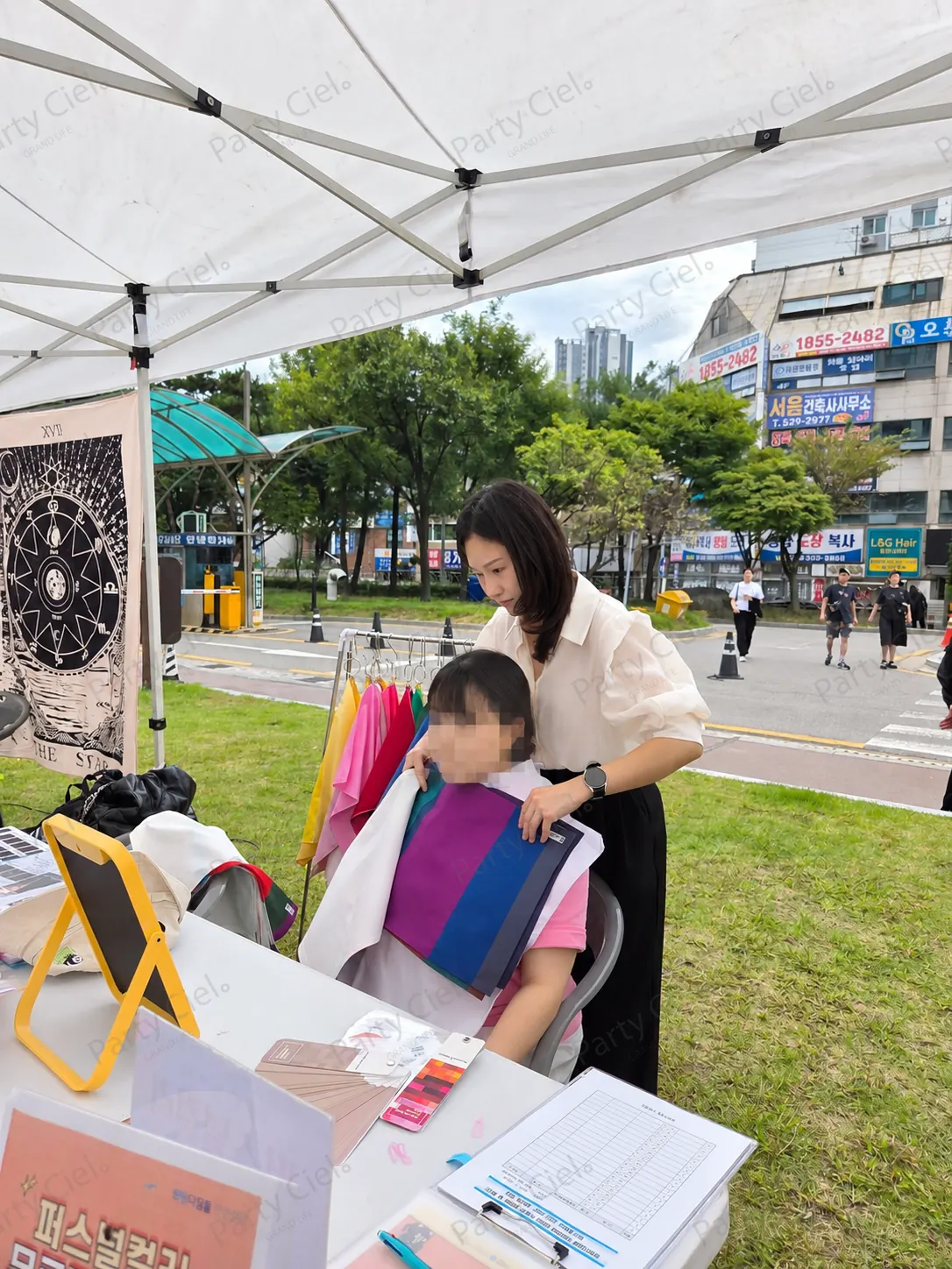 파티시엘 마스터가 참가자의 어깨에 보라·파랑 드레이핑 천을 대고 색을 비교하는 모습