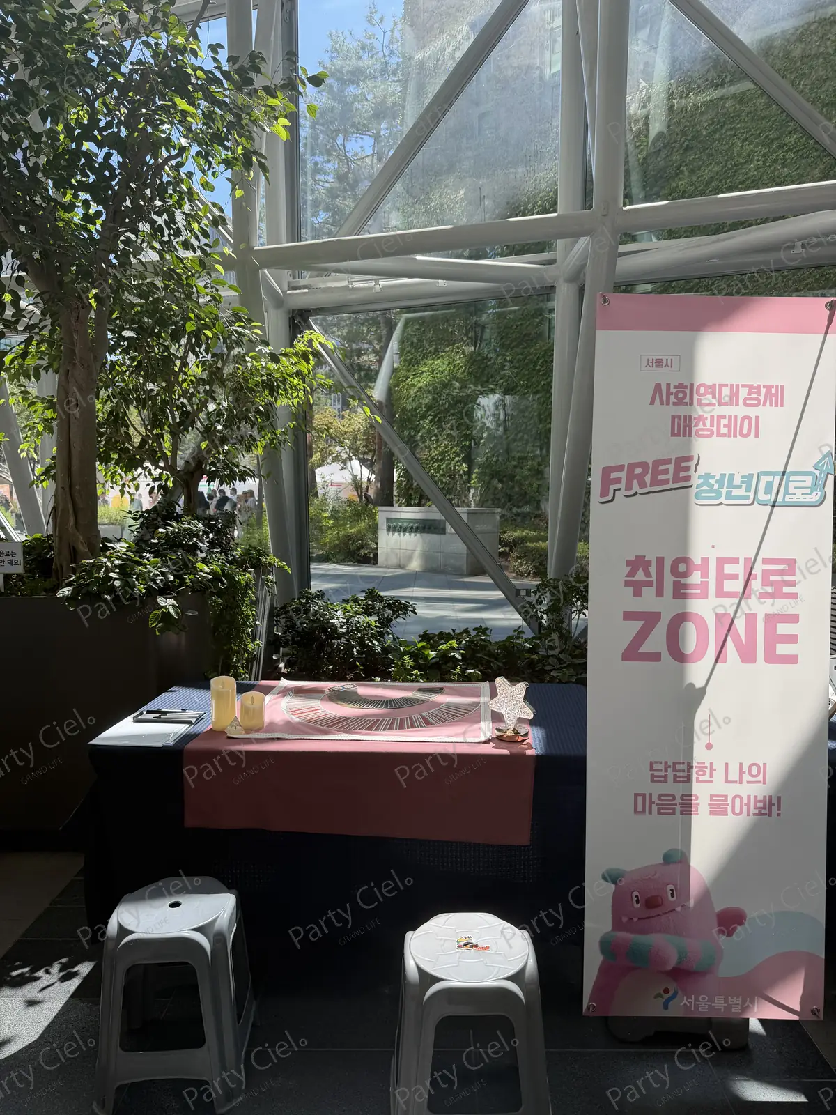 「취업타로 ZONE · 답답한 나의 마음을 물어봐!」 배너 옆, 타로카드가 펼쳐진 부스 테이블과 의자 두 개