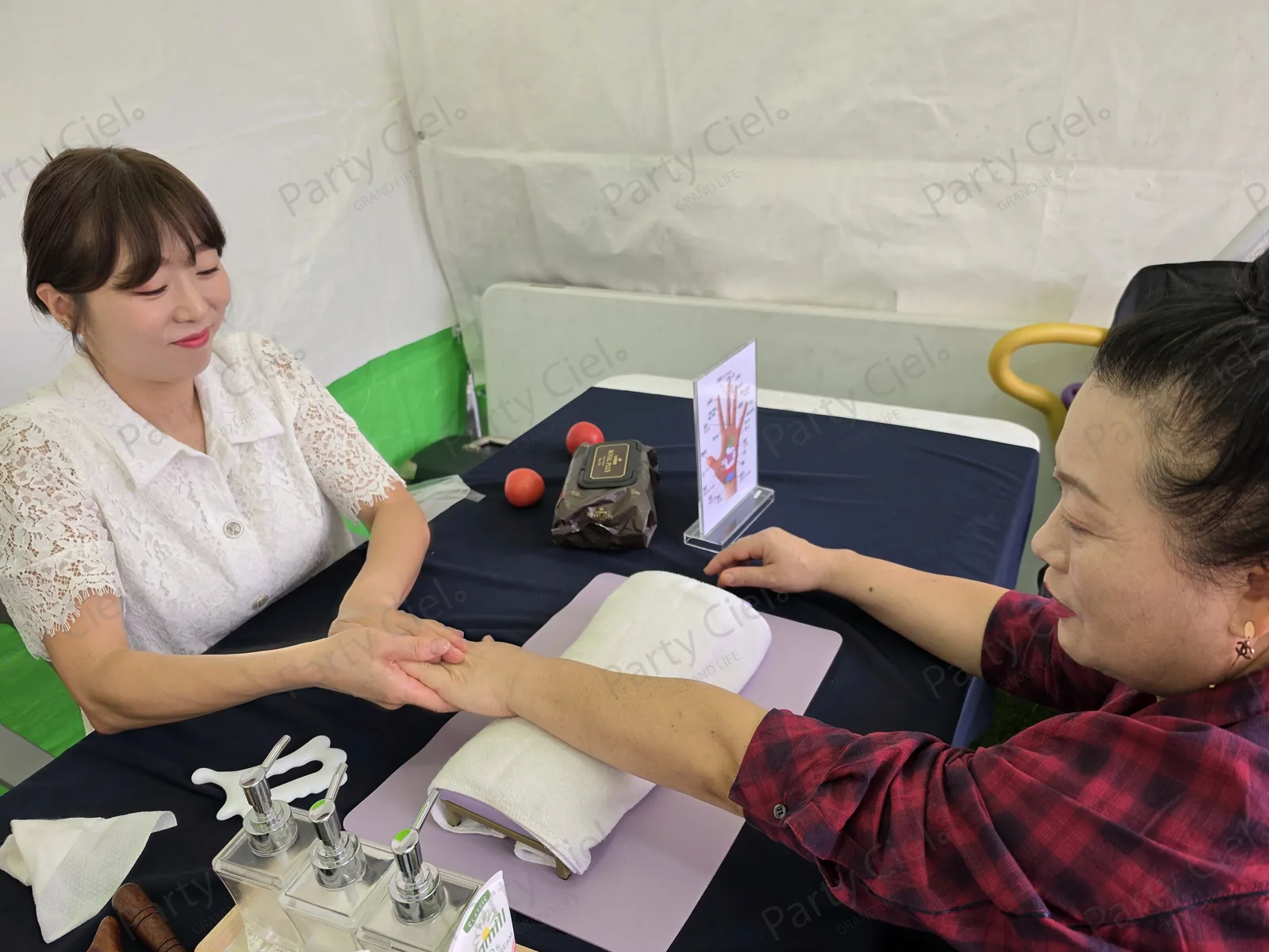 원주삼토페스티벌 파티시엘 핸드마사지 마스터가 참가자의 손을 잡고 핸드마사지를 진행하는 모습