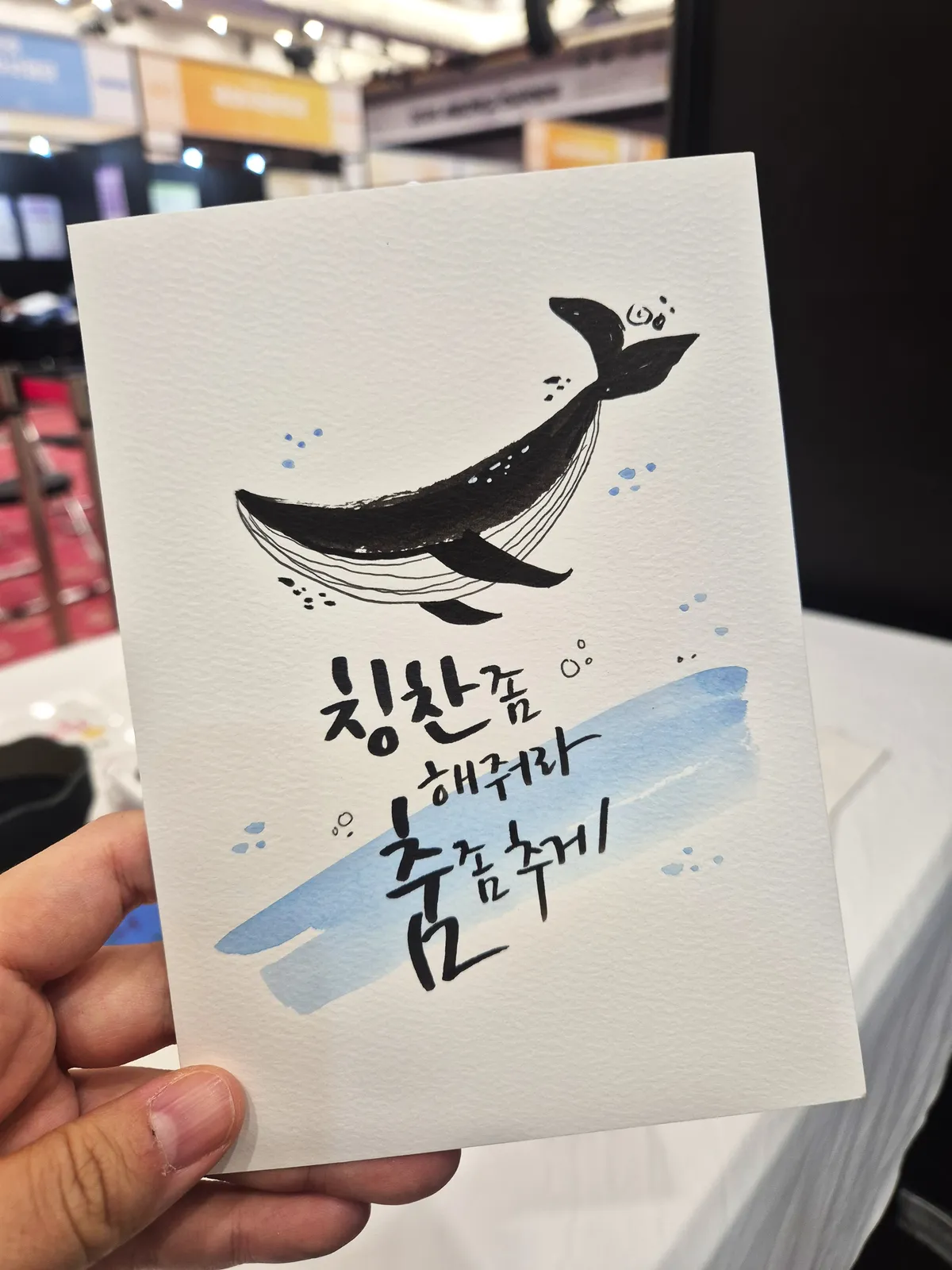 고래 그림과 손글씨 문구를 담은 캘리그라피 작품 카드 — 박람회 현장 제작