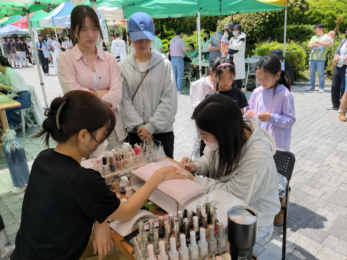 행사장 손 네일 시술 체험 현장 사진— 시술 장면