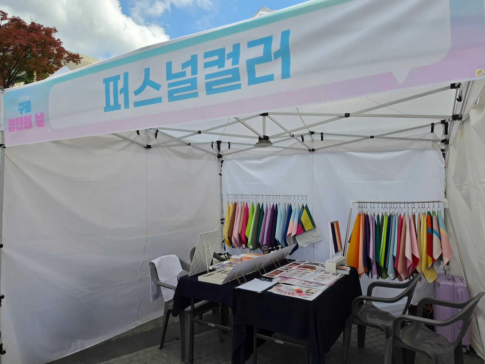 구로청년의날 신도림 디큐브시티 광장 퍼스널컬러 야외 부스 전경 — 컬러 드레이프 행거와 진단 테이블