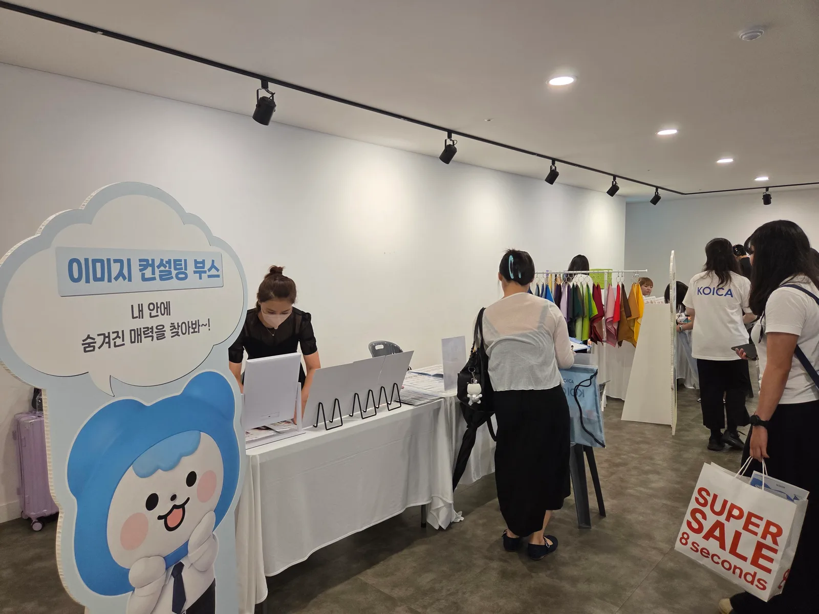 행사장 이미지 컨설팅 부스 운영 전경 — 컬러 드레이프 행거와 상담 테이블